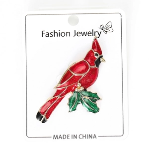Detailed close-up of a red cardinal bird brooch with vibrant enamel and green leaf accents