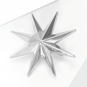 Detail of a polished silver octagonal star brooch with a sleek metallic finish