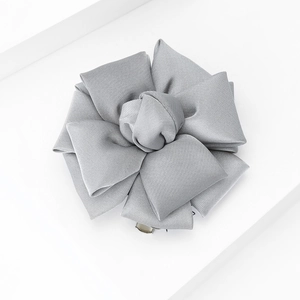 Detailed view of silver grey fabric flower brooch with layered satin petal texture