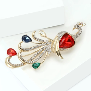 Detailed close-up of a peacock brooch featuring multicolored rhinestones and a red gem