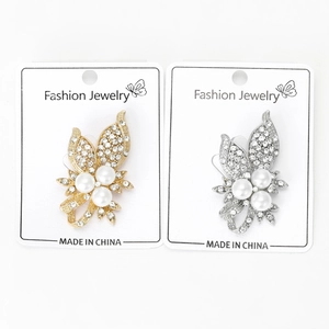 Détail de broches papillon avec strass et perles blanches sur cartes de bijoux
