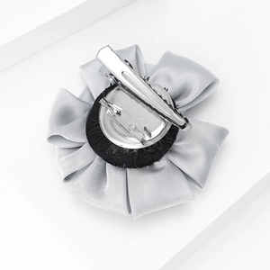 Macro view of the versatile flower brooch back with metal duckbill clip and safety pin