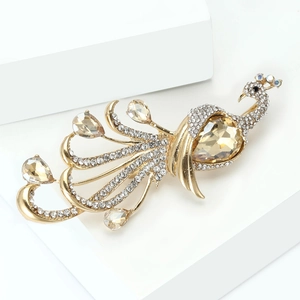 Detailed macro view of champagne teardrop gemstones on a gold peacock brooch