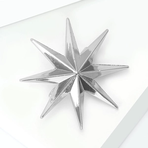 Detail shot of a silver octagram star brooch with a polished reflective metal surface