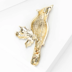 Detail view of the gold bird brooch back showing the secure safety pin and texture