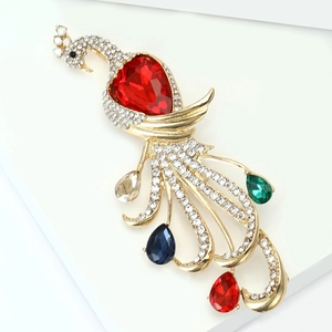 Detail of luxury peacock brooch with colorful crystals and large red pear-shaped stone