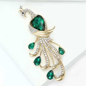Close-up of green crystal peacock brooch with gold alloy and sparkling rhinestones