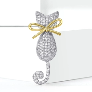 Broche chat scintillante avec zircons micro-pave et nœud doré sur décor géométrique