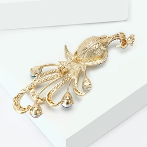 Detail view of peacock brooch back with sturdy pin buckle on polished gold alloy