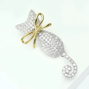 Broche chat scintillante avec zircons pavés et nœud doré sur fond blanc épuré