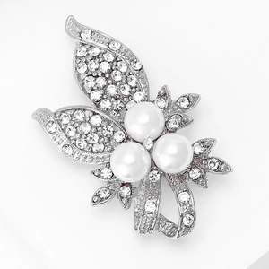 Gros plan sur l'élégante broche papillon argentée avec perles blanches et strass brillants
