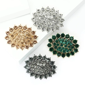 Luxury rhinestone sunburst brooches in four colors displayed on white geometric blocks