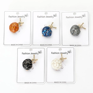 Vue détaillée de cinq broches escargot en émail de différentes couleurs avec cristaux