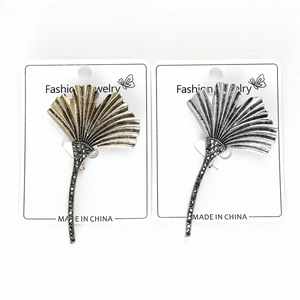 Detail of ginkgo leaf brooches in antique gold and silver with black rhinestone accents