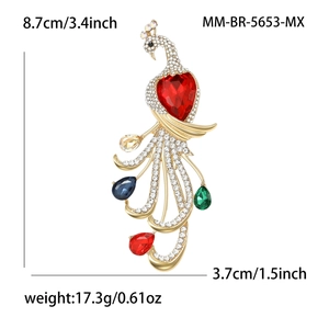 Peacock brooch with red heart stone and colorful crystals on white background