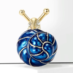 Détail d'une broche escargot avec coque en émail bleu profond et cristaux brillants