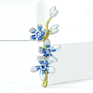 Elegant blue floral enamel brooch with pearl center on minimalist white background