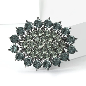 Macro detail of luxury rhinestone brooch with blue-grey crystal gradient on gunmetal base