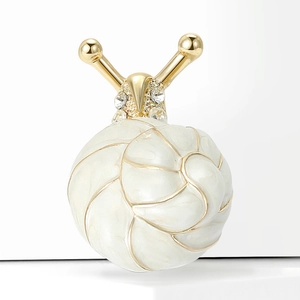 Détail de la broche escargot avec coquille en émail blanc, spirale dorée et strass