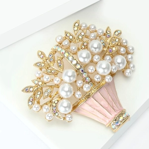 Detailaufnahme einer goldfarbenen Blumenkorb-Brosche mit weißen Perlen und Emaille