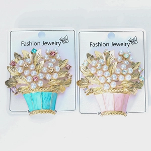 Detailed view of enamel flower basket brooches with white pearls and colorful rhinestones