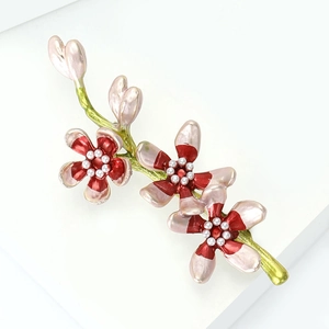 Close-up of pink enamel floral brooch with delicate petals and white faux pearl centers