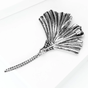 Macro shot of the silver ginkgo leaf brooch showing back pin structure and retro texture
