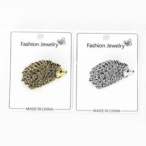 Close-up of cute hedgehog brooches in gold and silver finish with sparkling rhinestones