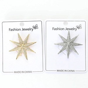 Detailed view of silver and gold eight-pointed star brooches with rhinestones