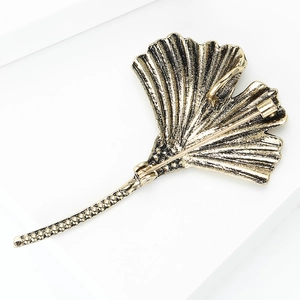 Detail view showing the back side of vintage golden ginkgo leaf brooch with safety clasp