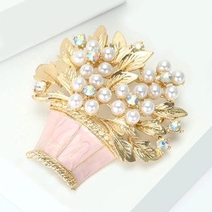 Close-up of golden enamel flower basket brooch with pearls and sparkling rhinestones