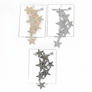 Detailed macro view of three star brooches with rhinestones in gold, silver and black