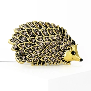 Retro hedgehog brooch in antique gold finish with champagne rhinestones on a white background