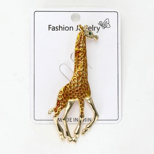 Close-up detail of giraffe brooch with enamel pattern and green rhinestone eye on card