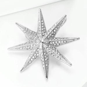 Macro detail of elegant silver starburst brooch with clear sparkling rhinestones