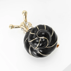 Détail de la broche escargot en émail noir avec motif spirale doré et accents en cristal