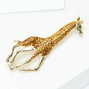 Golden giraffe brooch with yellow enamel spots and green rhinestone eye on white stand