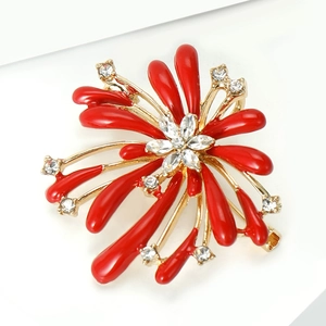 Macro shot of red enamel fireworks brooch with sparkling crystal center on gold base