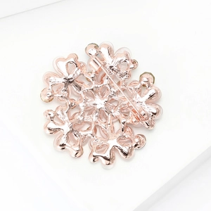 Detailansicht der Rückseite der Blumenbrosche mit Sicherheitsnadel und Roségold-Finish