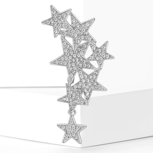 Detail of star-shaped brooch with shimmering rhinestones on white geometric background