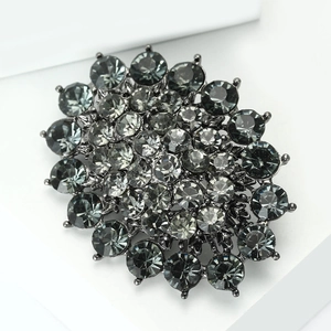 Macro view of vintage flower brooch featuring dark grey rhinestones and alloy texture