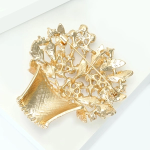 Detail view of the gold-plated basket brooch back with safety pin and hollow structure