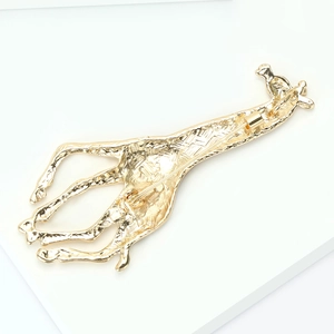 Detail view of the back of the golden giraffe brooch showing the secure pin lock mechanism