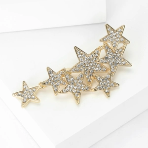 Detailed close-up of golden multi-star brooch with sparkling rhinestones and layered stars