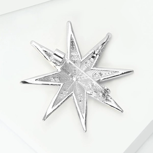 Detail view of the silver star brooch back showing the long pin and secure safety clasp