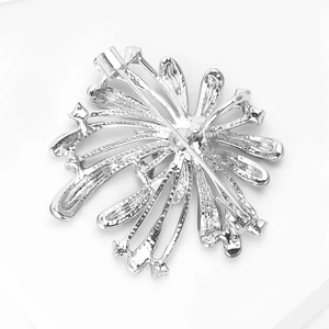 Close-up of the silver firework brooch back showing the secure safety pin fastening