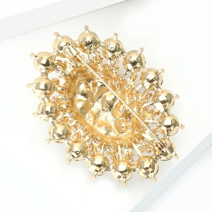 Detailed back view of vintage gold alloy bridal brooch with pin clasp and textured finish