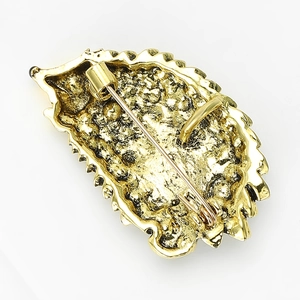 Detailed back view of a golden hedgehog brooch showing the metal pin fastener and texture