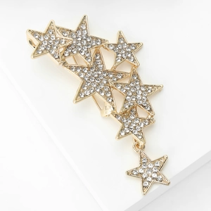 Detail of gold starburst brooch with shimmering crystals and hanging star pendant