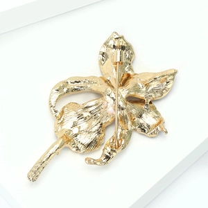 Detailansicht der goldenen Orchideenbrosche mit stabiler Anstecknadel und glatter Textur